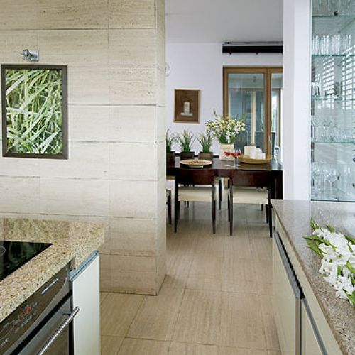 Do jasnych ścian i podłóg dobrano dla kontrastu ciemonobrązowy stół od Vinotti.