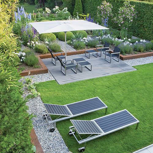 Do ogrodu idealnie dobrano małą architekturę. Tam, gdzie jest po miejsku, stoją chromowane fotele, a rabaty otoczone są