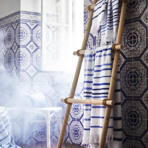 Leciutkie rattanowe fotele i ławki, kosze uplecione z morskich traw, lniana pościel w kolorze indygo,