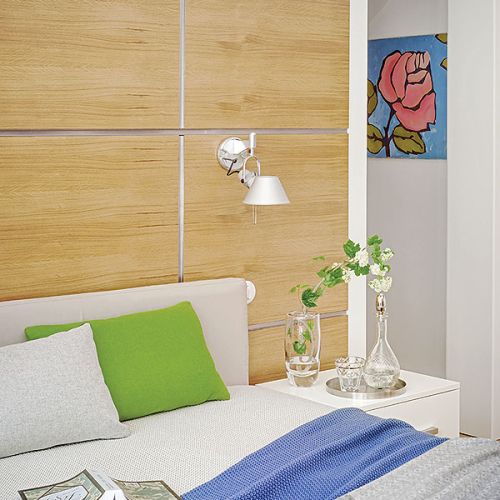 Drewniane kwadraty ułożone za łóżkiem stylistycznie nawiązują do elegancji stylu międzywojennego.