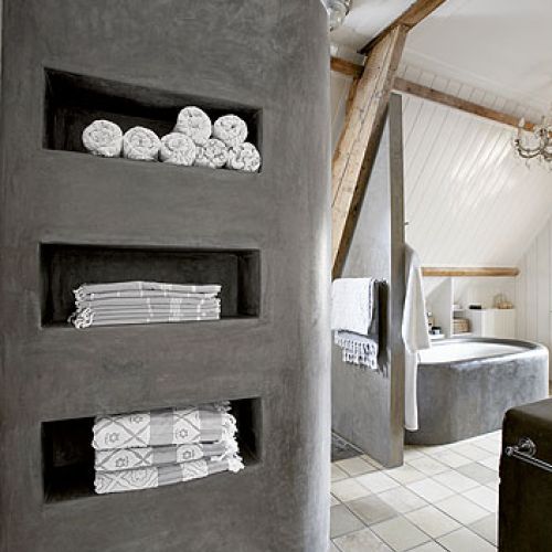 Drewniane wsporniki sufitu w surowo urządzonej łazience.