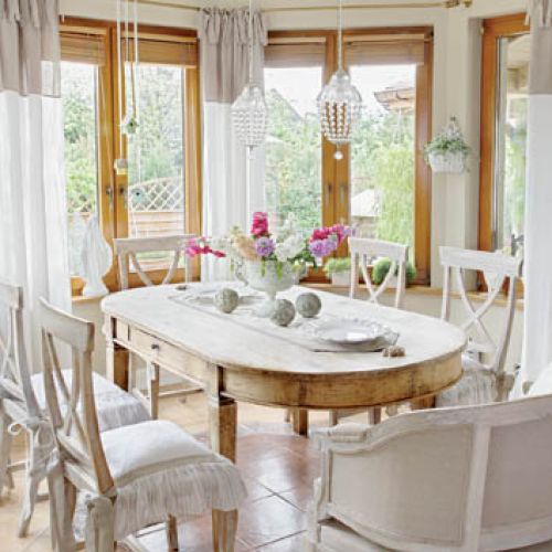 Drewniany stół został ustawiony tak, by można było podczas jedzenia podziwiać widok za oknami.