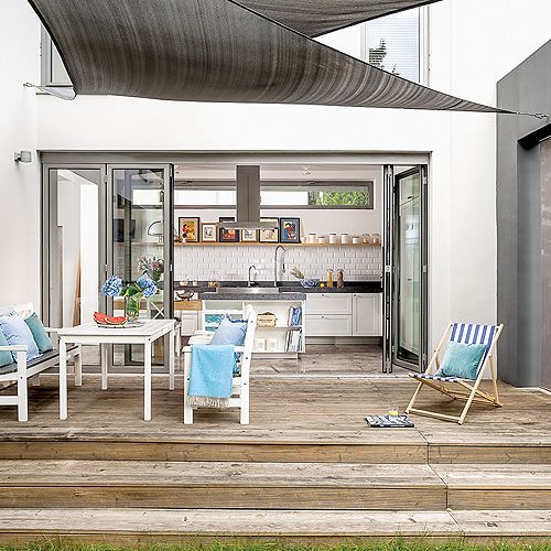 Drewniany taras zadaszony oryginalnymi markizami.