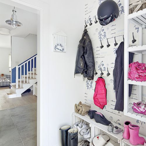 Drzwi do łazienek mają bulaje, a koło schodów wisi drewniany rekin wycięty z drewna starego kutra rybackiego.