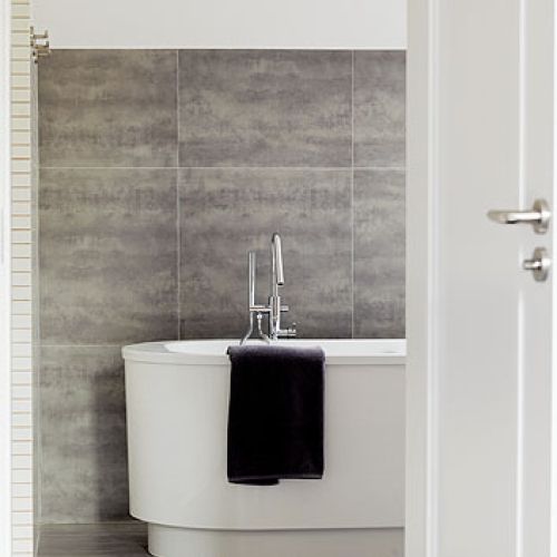 Duże, matowe płytki imitujące beton. To bardzo praktyczne rozwiązanie, bo kropelki wody są na nich praktycznie niewidoczne.