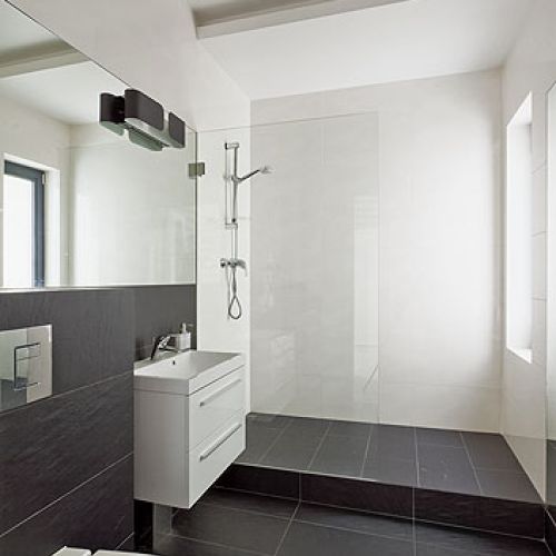 Duże, matowe płytki imitujące beton. Utzrymana w zimnej tomacji - biel, szarość i czerń.