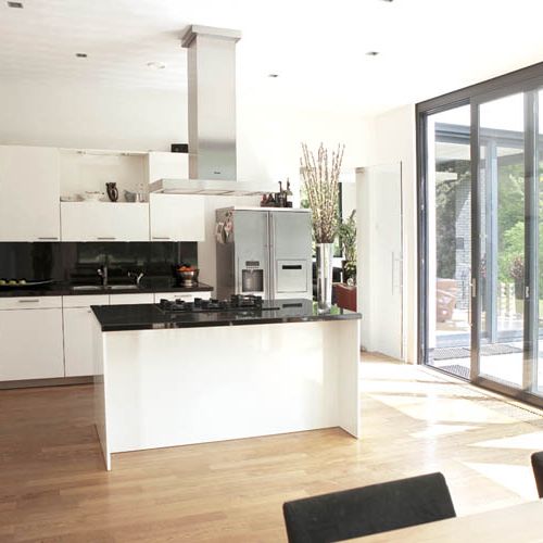 Dużo okien, mało mebli. Nowoczesny kubik w lesie