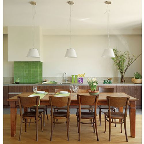 Duży rodzinny stół stoi między kuchnią a salonem.