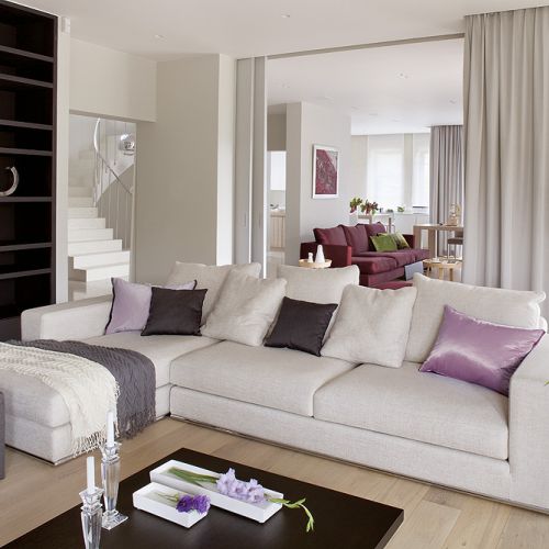 Duży salon można przedzielić drzwiami obitymi tkaniną. Obie kanapy właściciele kupili w Casa Marvell. Stół i stolik kawowy -