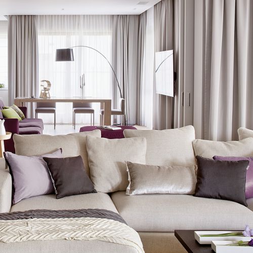 Duży salon można przedzielić drzwiami obitymi tkaniną. Obie kanapy właściciele kupili w Casa Marvell. Stół i stolik kawowy -