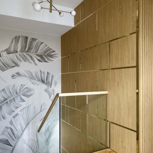 nowoczesne wnętrze z drewnianą ścianą i szklaną balustradą