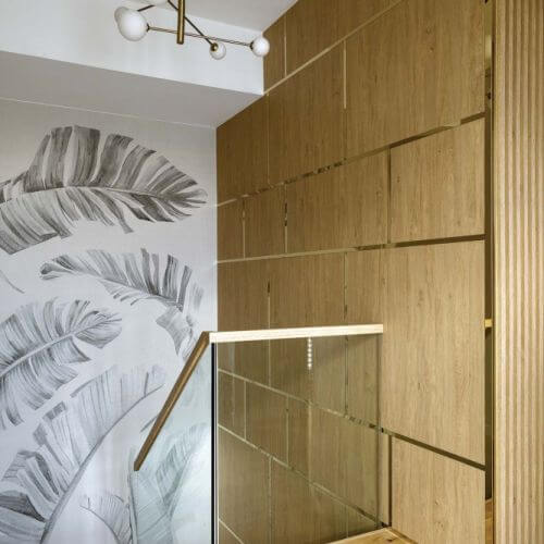 nowoczesne wnętrze z drewnianą ścianą i szklaną balustradą