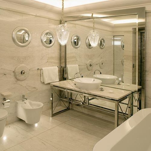 Dziecięca łazienka, jak na Titanicu – luksusowa armatura, piaskowy marmur, okrągły kaloryfer i lustra-bulaje.