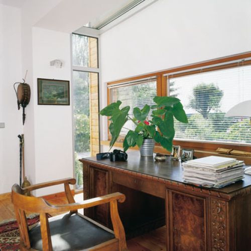 Dzięki przeszkleniu bocznych ścian gabinet pana domu został dosłownie wypchnięty do ogrodu.