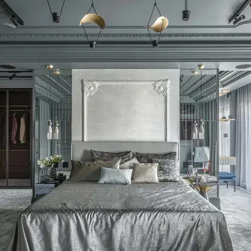 elegancka sypialnia z łóżkiem, tapetą w sztukateryjnej ramie i ścianą z lustrzanych płytek