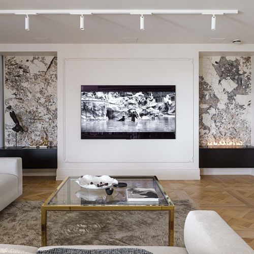 telewizor w salonie obramowany sztukaterią i biokominkiem w kamiennej obudowie