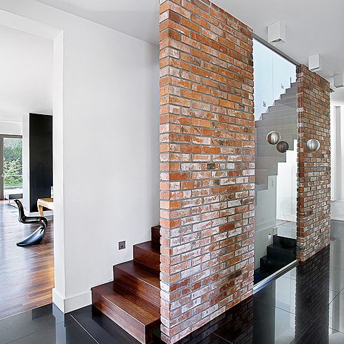 Elementem dekoracyjnym jest ściana z cegieł - taka sama jest także w kuchni.