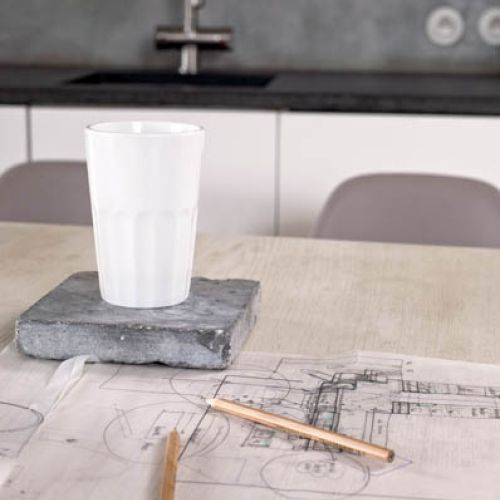 Kuchnia minimalistyczna, ale z ciekawymi krzesłami i drewnianym stołem na pięknych nogach.