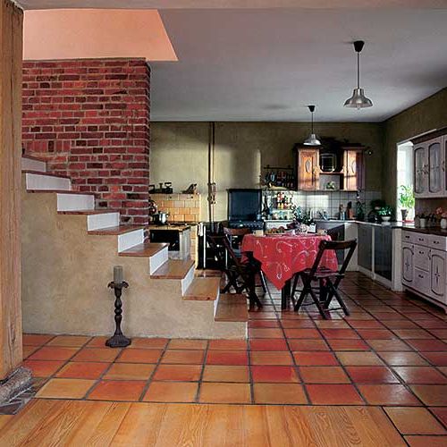 Gołe gliniane tynki, cegła uratowana z rozebranej stacyjki kolejowej, ręcznie formowane gliniane płytki cotto, kamie