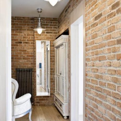 Industrialne lampy z Ikea i grzejnik Charleston firmy Zehnder w towarzystwie babcinego fotela z Rad-