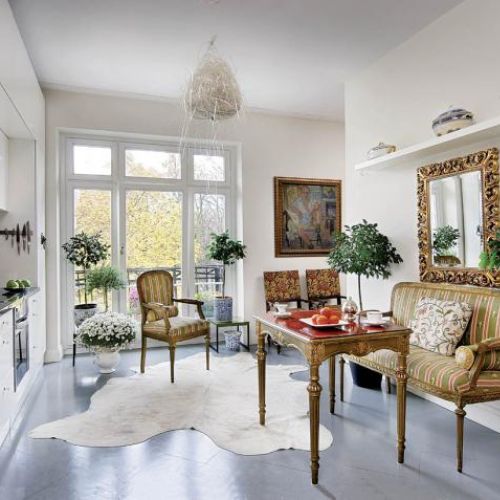 Intrygujące zestawienie: nowoczesna, oszczędna kuchnia- meble i lustro jak z pałacu. A na podłodze klepka