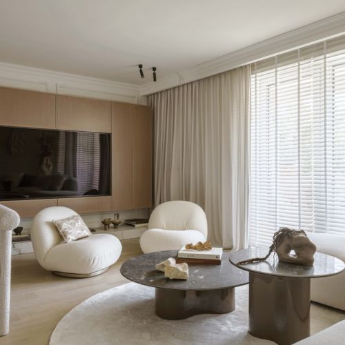 jasny salon ze sztukateriami i fotelami boucle