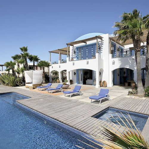 Jak w domach na Capri: biała elewacja i błękitne obramowania okien i drzwi.