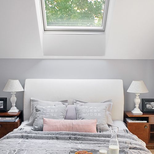 Kameralna sypialnia pod skosami z widokiem na las. Futro i poduszki to BBHome.