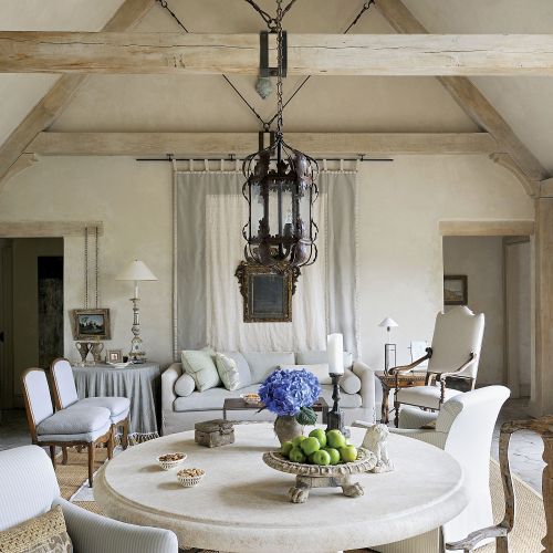 Kamienny stół i kute żyrandole nadają wnętrzu prowansalskiego klimatu.