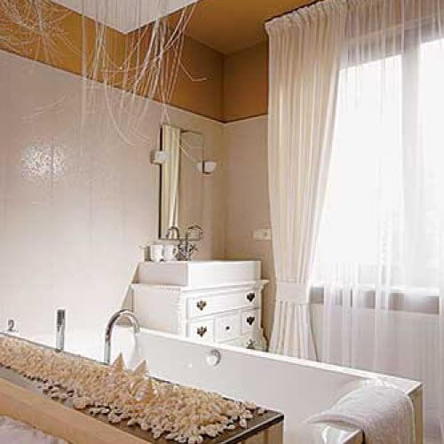 Kąpielowa część sypialni jest bardzo kobieca. Delikatny ornament na glazurze, niczym ze starej tapety, czarodziejska