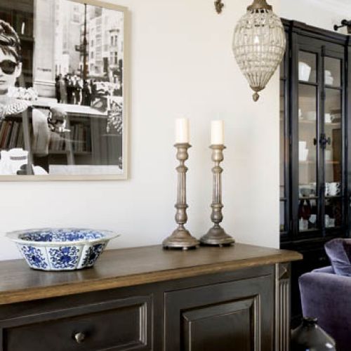 Kinkiet zdobiony kryształami oświetla miejsce nad komodą.