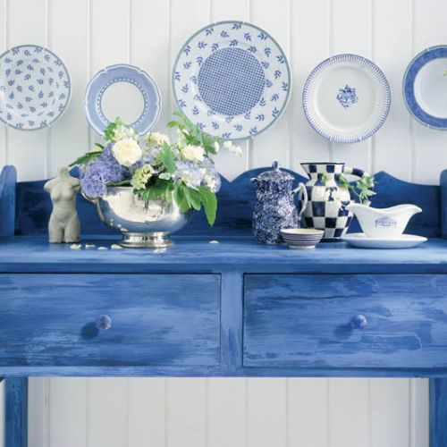 Kobaltowe talerze nad niebieską konsolą.