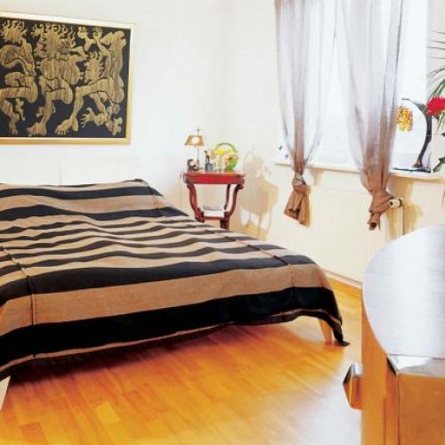 Kobieca sypialnia urządzona w ciepłych kolorach.