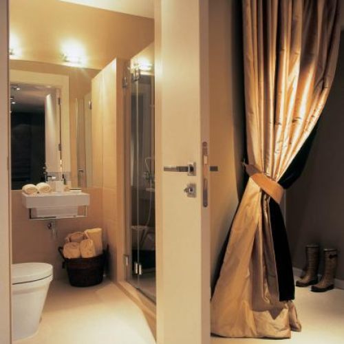 Kobiece, wygodne rozwiązanie. Za elegancko upiętą kotarą z tafty kryje się otwarta garderoba.