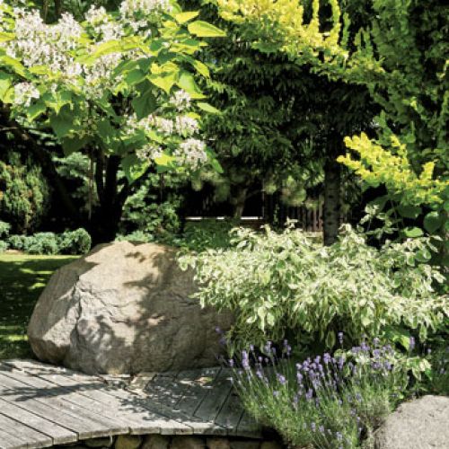 Kominek i dwa grile to sprzęty niezbędne w letniej kuchni. Ogród miłosników podróży i gotowania.