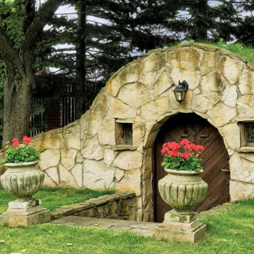 Kominek i dwa grile to sprzęty niezbędne w letniej kuchni. Ogród miłosników podróży i gotowania.