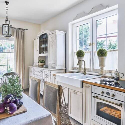 Jak urządzić wnętrze w stylu prowansalskim? Malowanymi antykami, tkaninami w pastelowych kolorach, starą ceramiką, kwitnącą