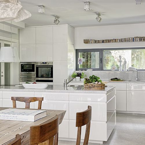 Kuchnie zaprojektowano pod wymiar dużego modrzewiowego stołu. Drewno pomalowano tak, by widoczne były słoje.