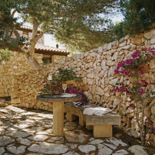 Ławeczka pod kamiennym murem to świetne miejsce na chwilę relaksu.