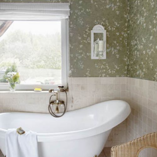 Łazienka na parterze wygląda jak mały włoski salon kąpielowy. To zasługa romantycznej tapety.