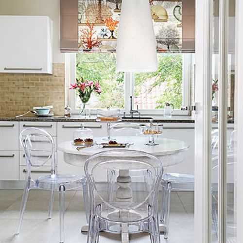 Meble włoskie Mobilegno, stary stół został pomalowany na biało, a towarzyszą mu przezroczyste krzesła marki Calligars.