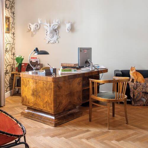 W gabinecie stanęło oryginalne biurko w stylu art déco w orzechowym fornirze. Na ścianie wiszą stare sztychy, ale też
