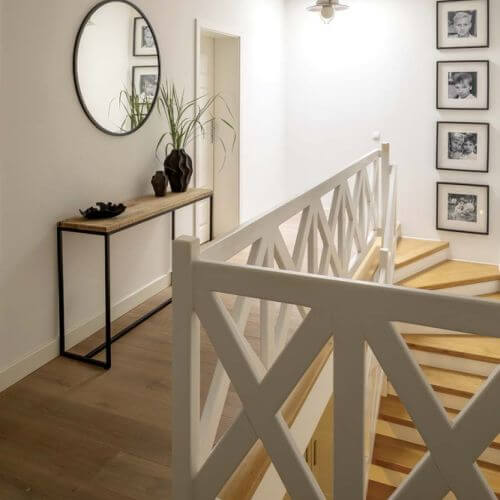 nowoczesny przedpokój ze schodami z białą balustradą o geometrycznym wzorze