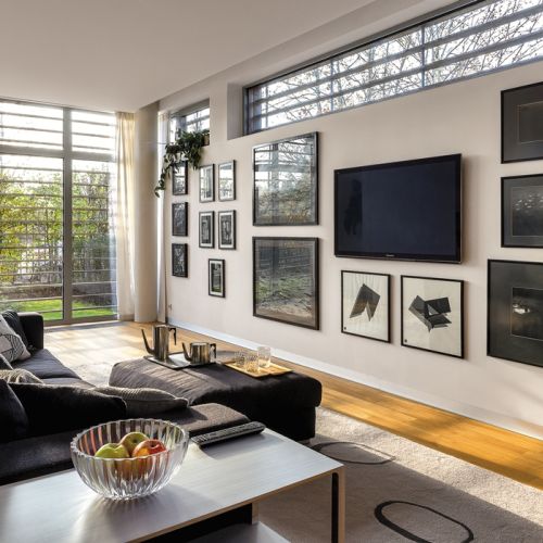 Dobry pomysł na ukrycie telewizora wśród artystycznej kolekcji. Na ścianie wiszą prace Ryszarda Winiarskiego, Mikołaja