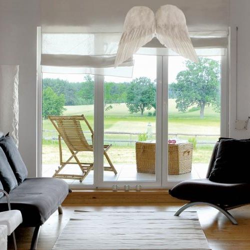 Na drzwiami prowadzącymi na taras wiszą anielskie skrzydła.