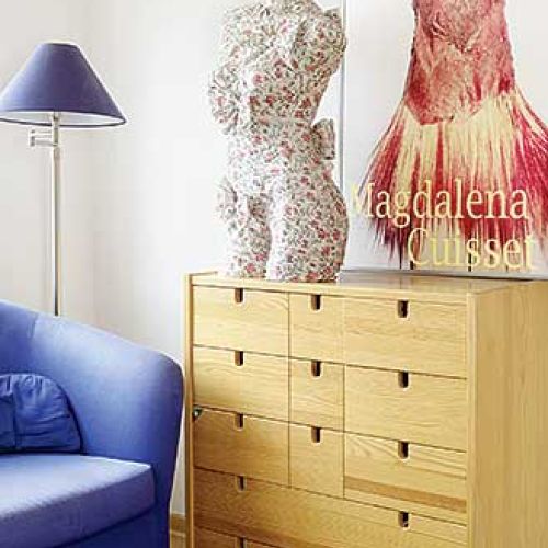 Na komodzie stoi ubrany manekin. Kobieta i lampy