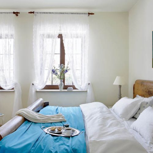 Na łóżku w sypialni leży lazurowa narzuta - to z tęsknoty za lazurem wody.