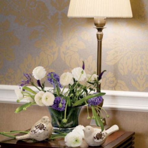 Na nocnym stoliku, obok lampki, rozgościły się ceramiczne ptaszki.