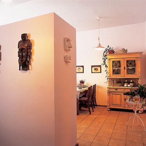 Na ścianie wiszą dekoracyjne maski. W poznańskiej kamienicy