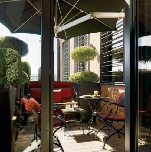 Na tarasie stoi komplet mebli. Apartament pełen smaków